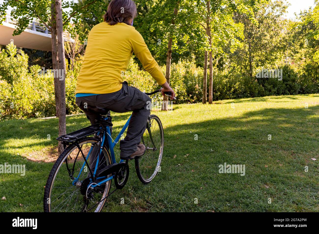 Homme méconnaissable dans le parc avec son vélo. Banque D'Images