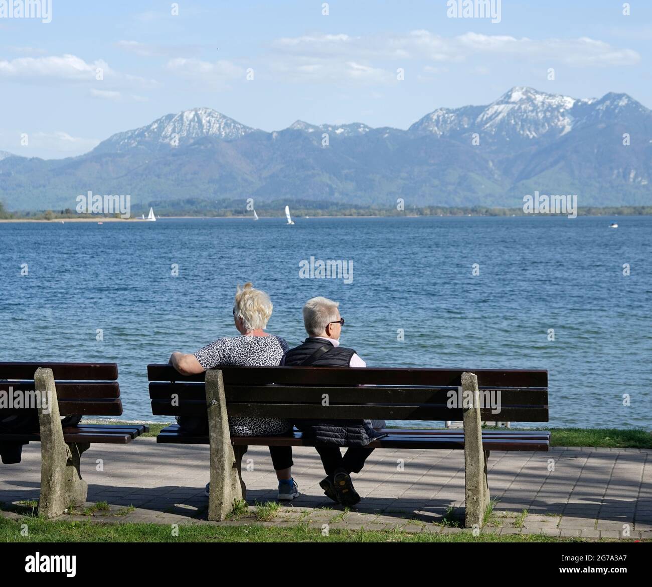 Allemagne, Bavière, haute-Bavière, Chiemgau, Prien, Chiemsee, promenade au bord de la rivière, couple retraité sur un banc de parc Banque D'Images