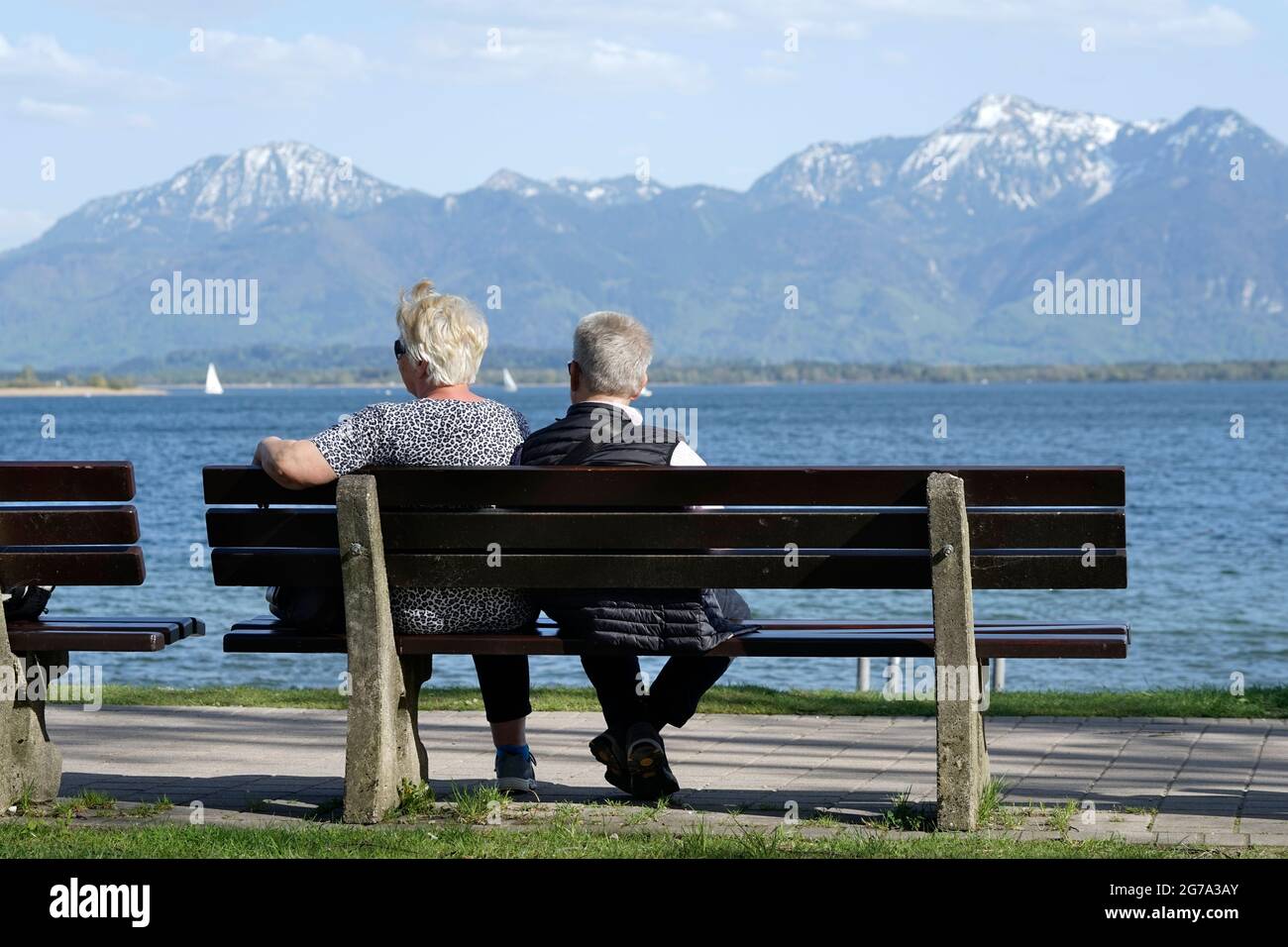 Allemagne, Bavière, haute-Bavière, Chiemgau, Prien, Chiemsee, promenade au bord de la rivière, couple retraité sur un banc de parc Banque D'Images