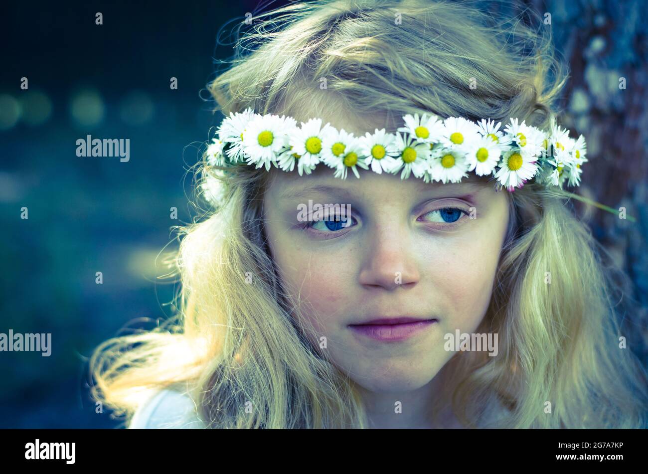 adorable petite fille blonde souriante avec serre-tête à fleurs et effet filtré Banque D'Images