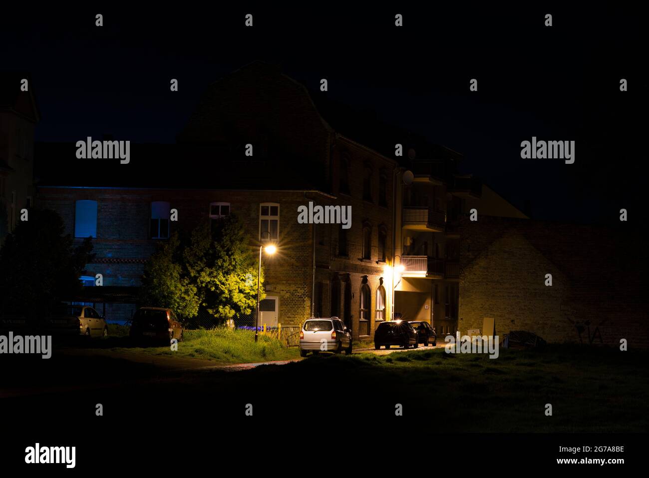 La nuit dans la rue, rue Dark Side avec des voitures garées dans la ville de Luckenwalde en Allemagne Banque D'Images