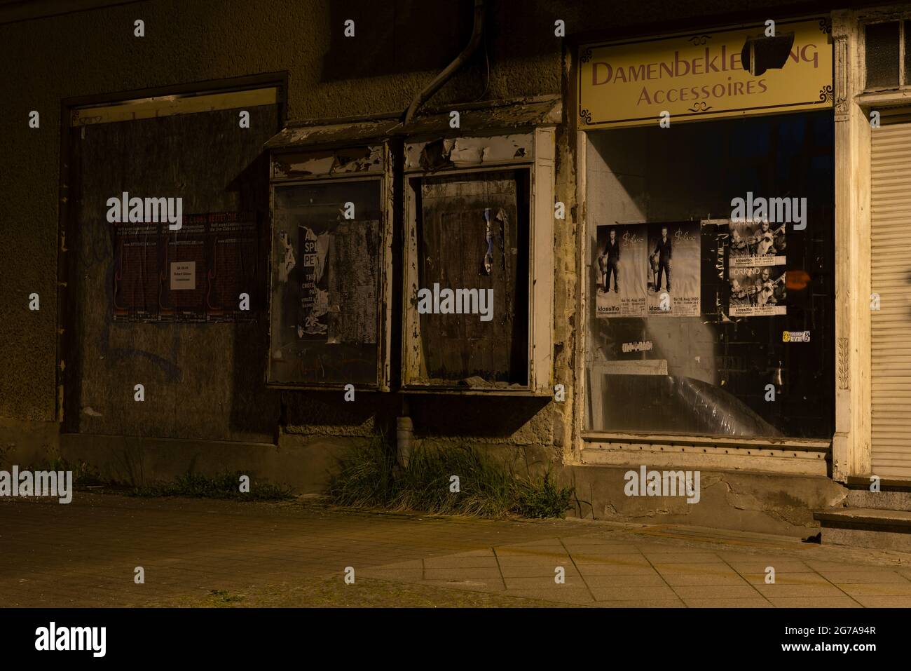 La nuit dans la rue, maison inhabitée au bord de la route avec de vieux magasin de vêtements pour femmes Banque D'Images