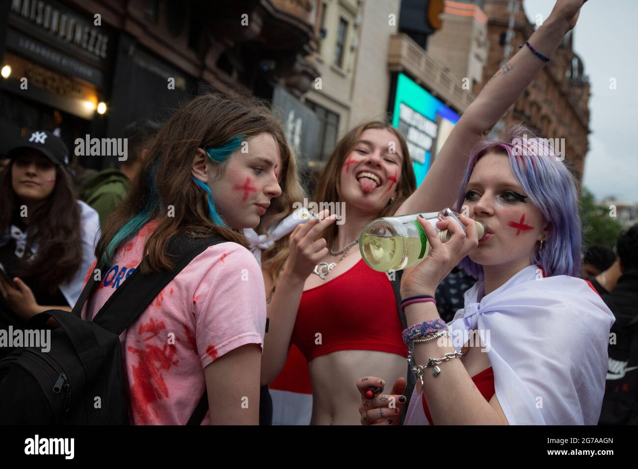 Trois jeunes femmes fans d'Angleterre sur Leicester Square devant l'Euro 2020 final Angleterre contre l'Italie. Banque D'Images
