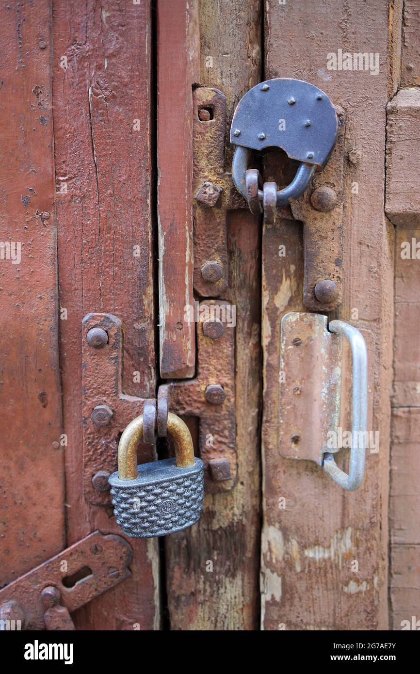 Vieilles portes de grange, avec peinture écaillée, avec deux grandes serrures en métal sur elles. Répétition Banque D'Images