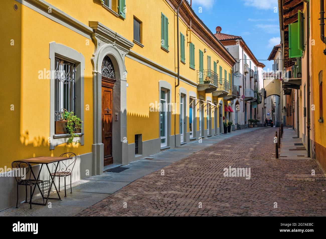 Rue pavée étroite et maisons colorées dans la vieille ville d'Alba dans le Piémont, dans le nord de l'Italie. Banque D'Images