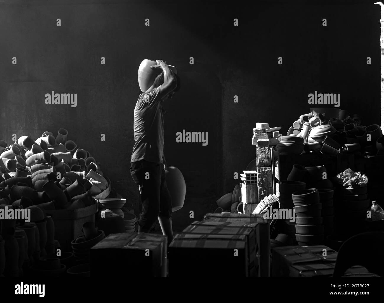 Personnes travaillant sous les faisceaux de lumière de l'atelier de poterie Menemen Banque D'Images