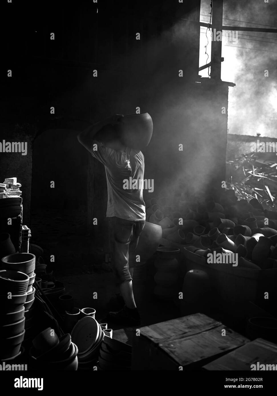 Personnes travaillant sous les faisceaux de lumière de l'atelier de poterie Menemen Banque D'Images