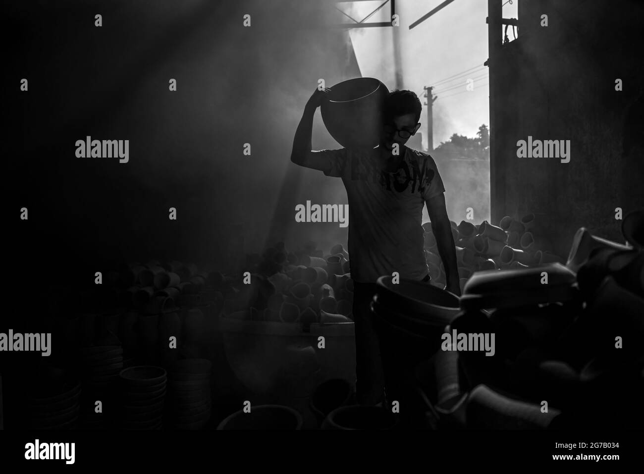 Personnes travaillant sous les faisceaux de lumière de l'atelier de poterie Menemen Banque D'Images