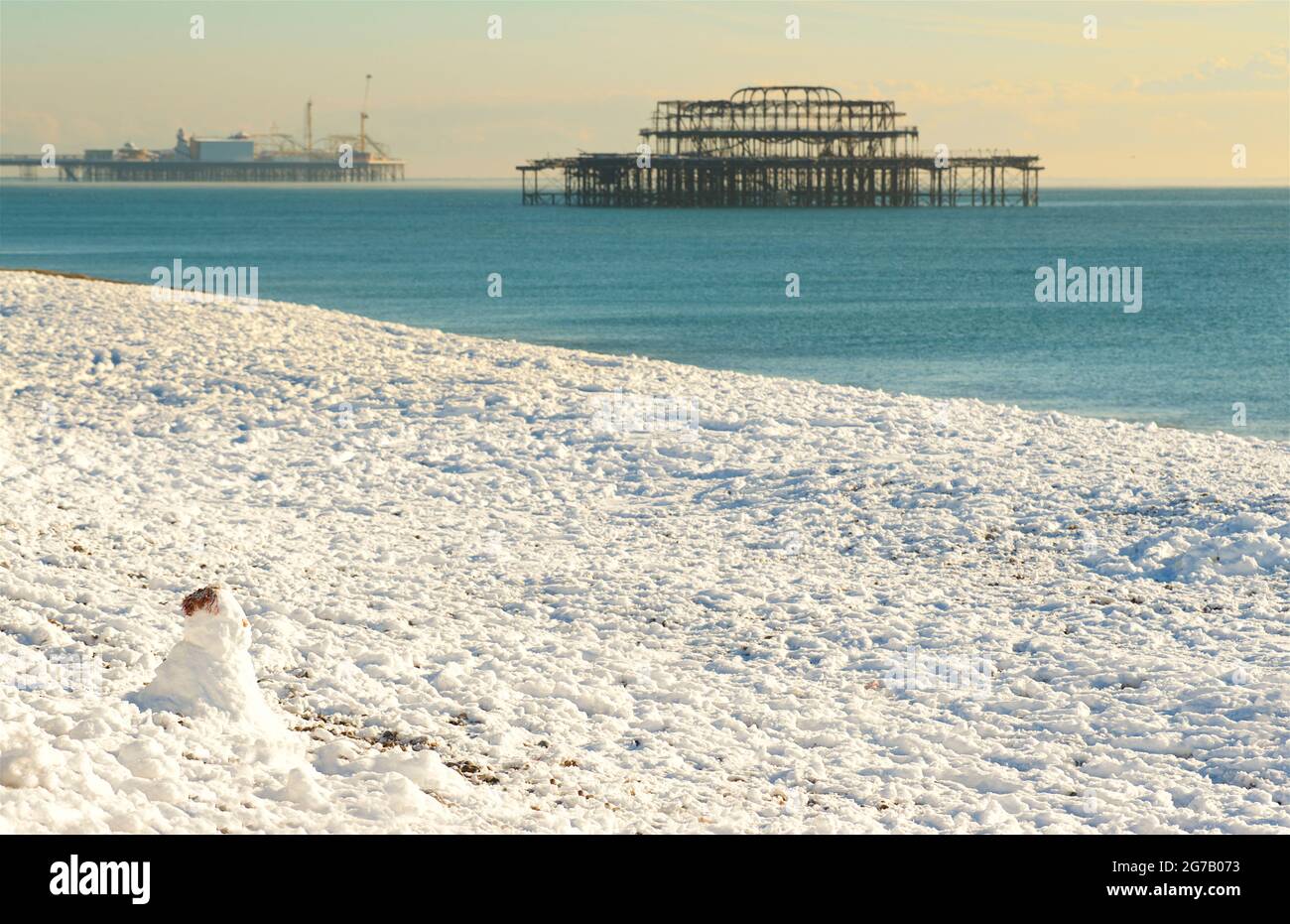 Neige sur la plage, Brighton, Angleterre, avec le Palace Pier et les vestiges de la jetée ouest derrière. Concentration sur Snowman sur la plage Banque D'Images