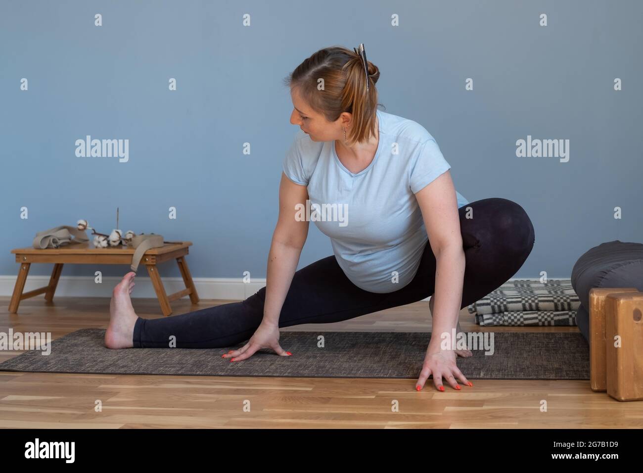 Femme enceinte de race blanche debout dans l'asana de yoga Banque D'Images