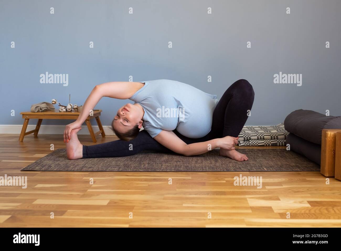 Femme enceinte de race blanche assise au yoga asana Banque D'Images