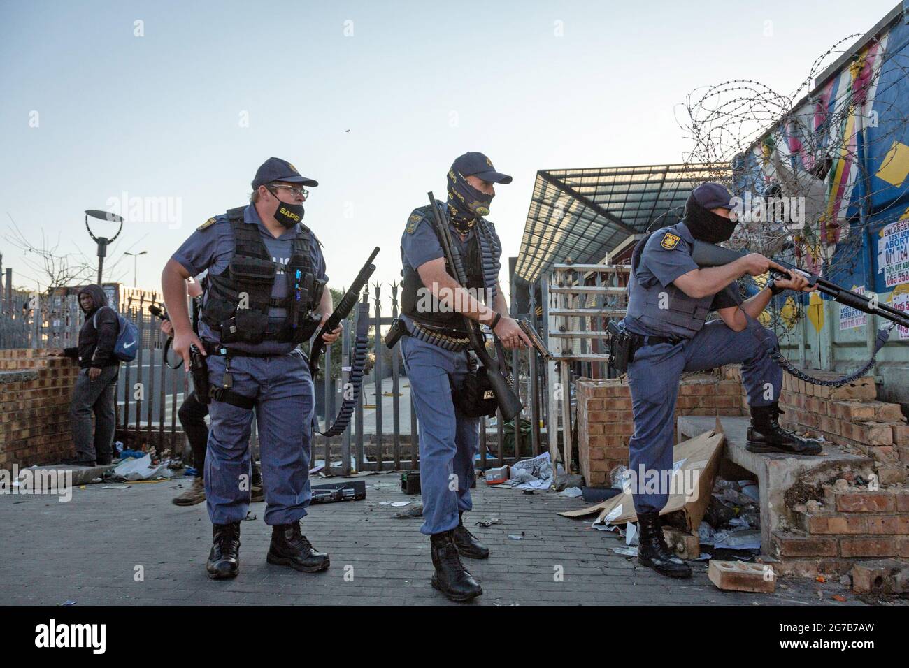 (210712) -- JOHANNESBURG, le 12 juillet 2021 (Xinhua) -- les policiers sont en position de faire face au pillage à Johannesburg, en Afrique du Sud, le 12 juillet 2021. Des soldats ont été déployés dans les provinces du KwaZulu-Natal et du Gauteng pour faire face à de violentes manifestations et des pillages, a déclaré l'armée sud-africaine lundi. La police a déclaré que six personnes avaient été tuées et 219 personnes arrêtées au cours du week-end à Gauteng et KwaZulu-Natal à la suite de manifestations violentes après que l'ancien président Jacob Zuma ait été emprisonné pendant 15 mois pour outrage au tribunal. Des centaines de magasins et d'entreprises des deux provinces ont été pillés. (Photo par Oui Banque D'Images