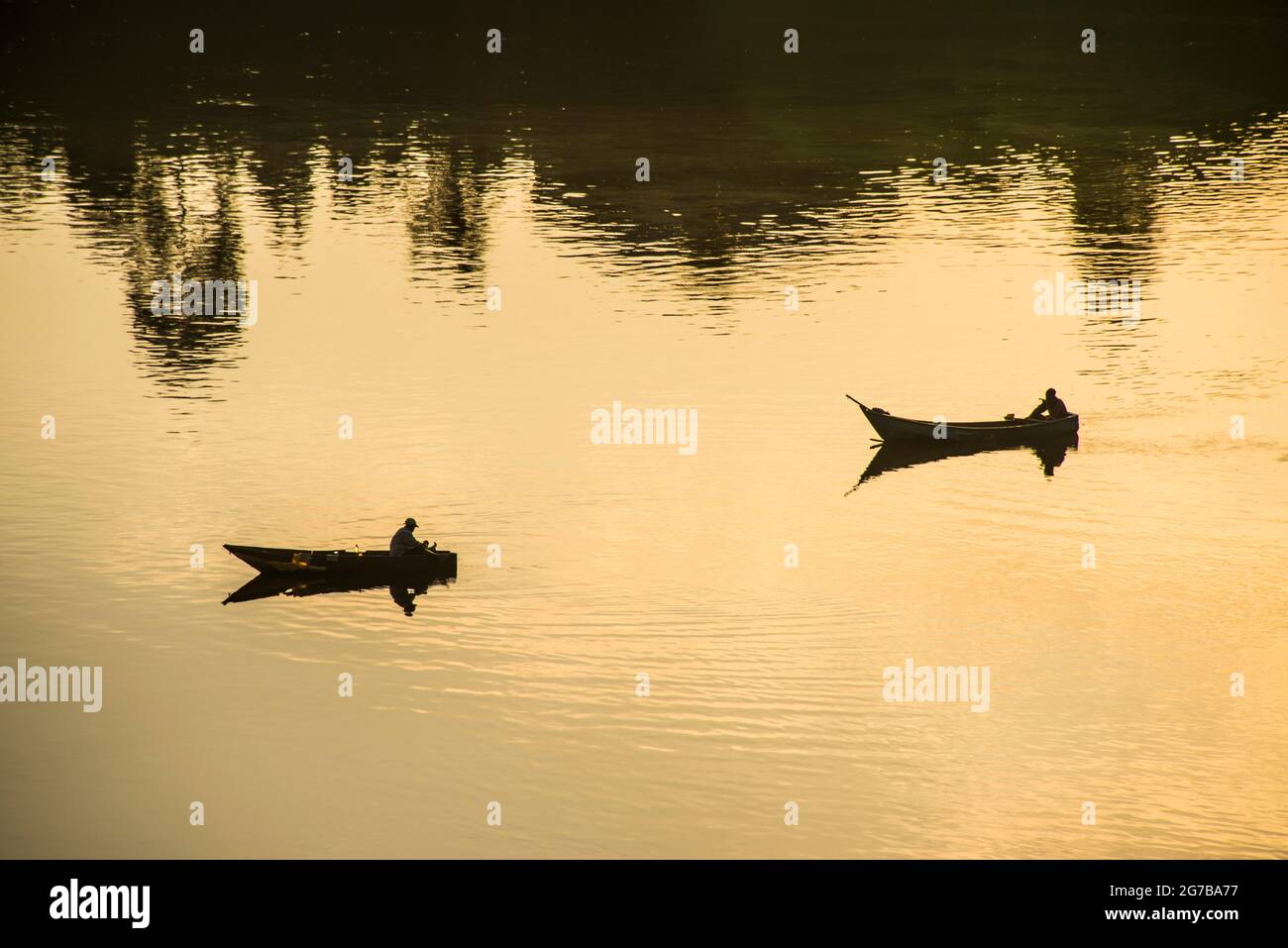 Pêcheurs dans leurs canots pêchant au coucher du soleil sur le Nil à la source de Jinja du Nil, Ouganda, Afrique Banque D'Images