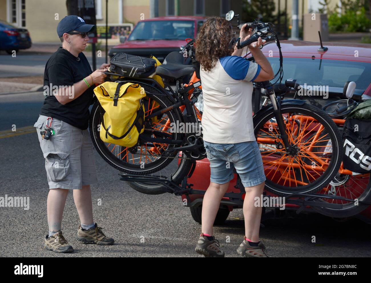 Deux cyclistes déchargent leurs vélos électriques alors qu'ils se préparent à explorer Santa Fe, Nouveau-Mexique. Banque D'Images