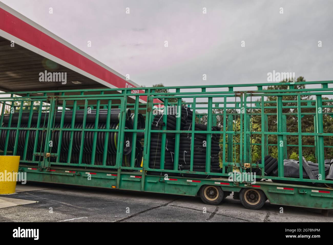 Une remorque à cage verte sur un semi-camion avec tubes en plastique noir  en rouleaux remorque extra-longue - autoroute 1 Photo Stock - Alamy