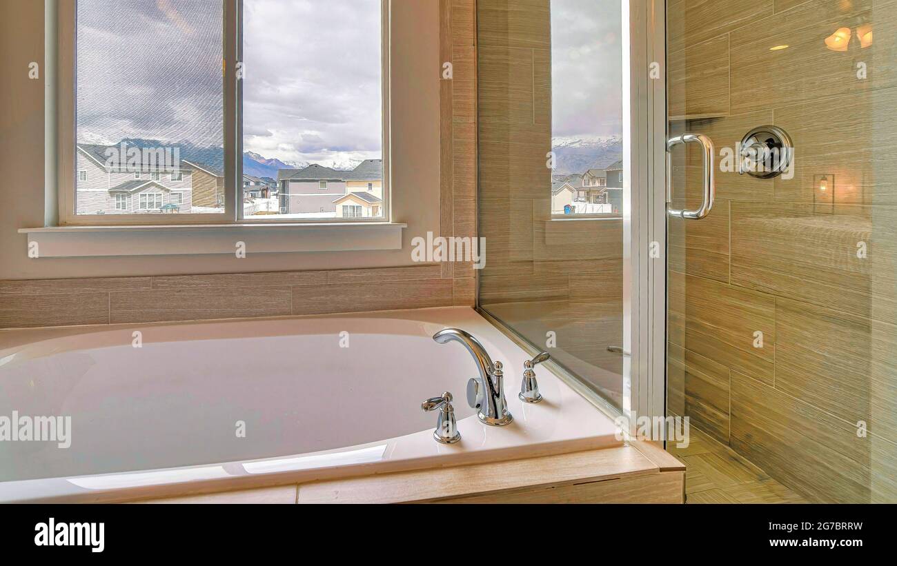 Cabine de douche Pano avec mur en verre et porte à côté de la baignoire