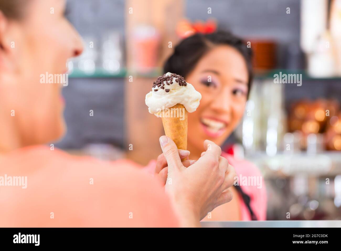 Les jeunes filles et client dans une vendeuse de glaces avec de la glace cornet Banque D'Images