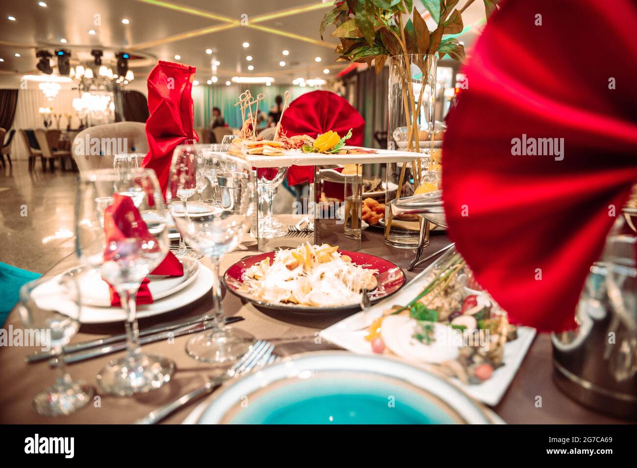 une table dans un restaurant en vacances avec des serviettes rouges. Banque D'Images