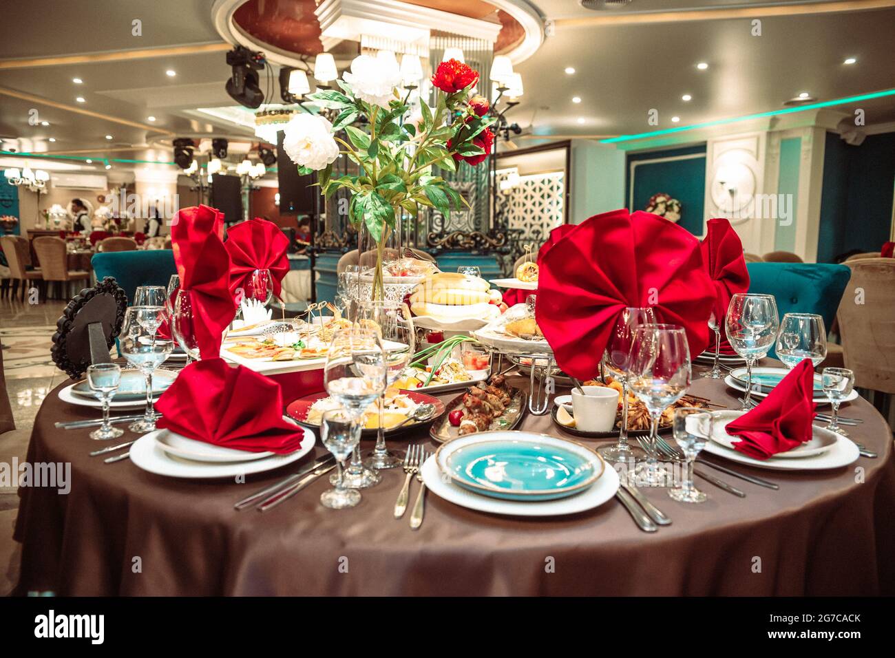 une table dans un restaurant en vacances avec des serviettes rouges. Banque D'Images