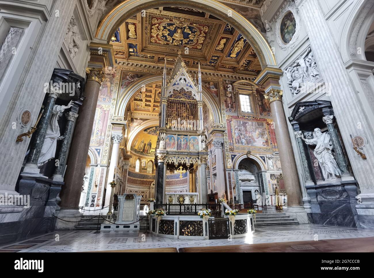 Vue en perspective de l'abside de la cathédrale de Rome de San Giovanni à Laterano, avec l'autel papal, le plafond incrusté et la voûte avec des fresques. Banque D'Images