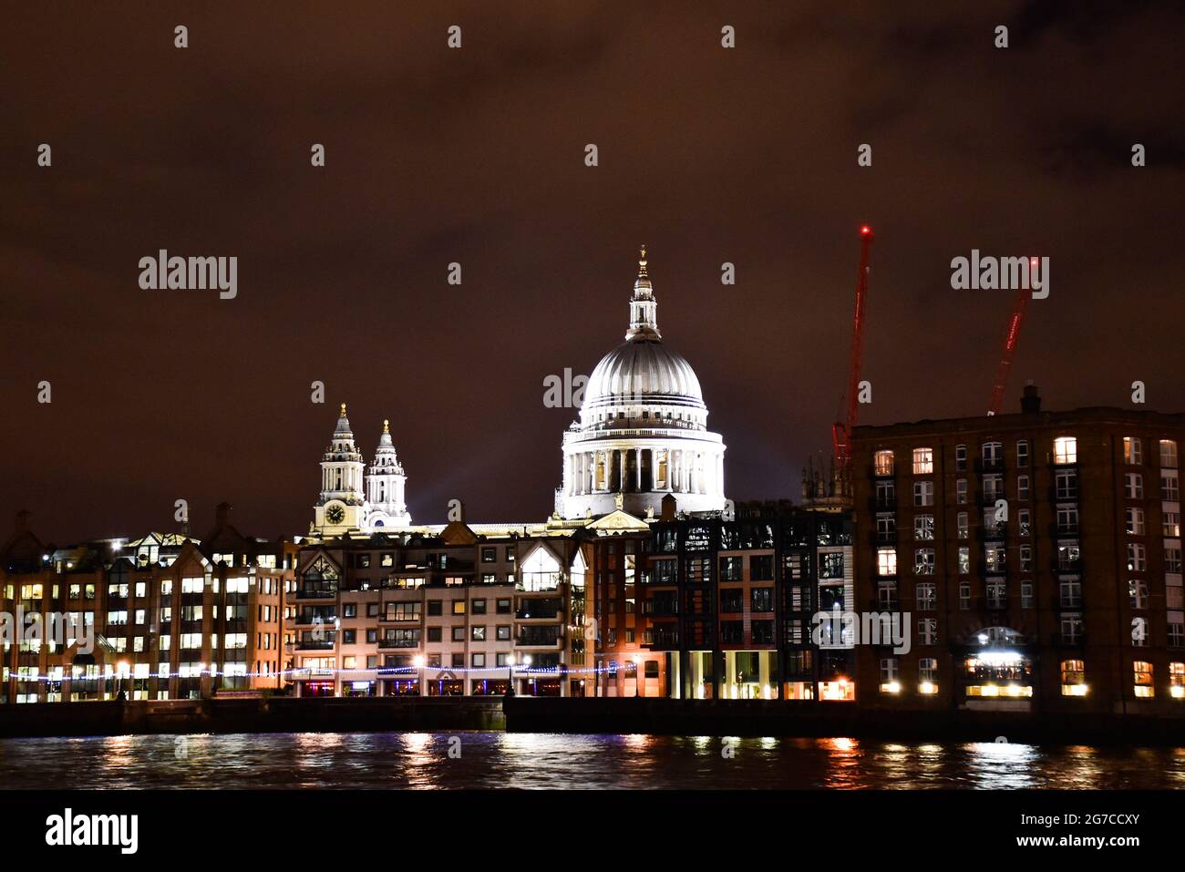 Vue nocturne sur la Tamise avec les bâtiments éclairés et le dôme de la cathédrale Saint-Paul. Banque D'Images