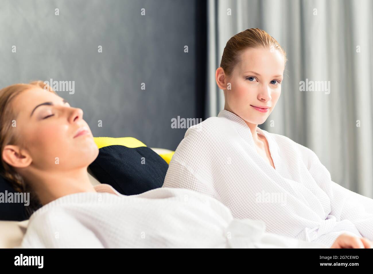 Deux belles femmes en peignoir se détendant au spa Banque D'Images