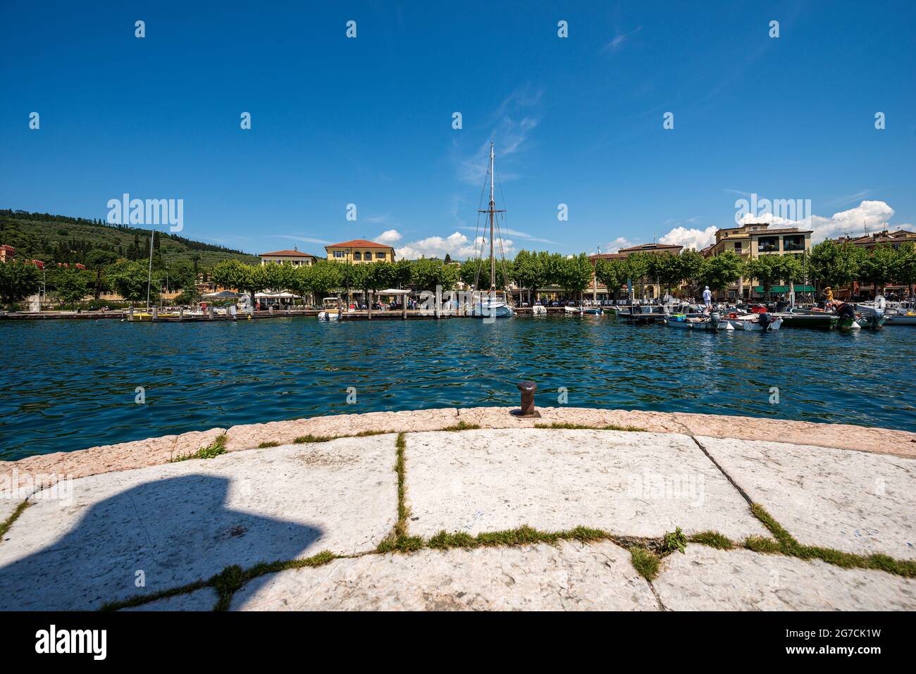 Petit port de la ville de Garda avec de petits bateaux amarrés, station touristique sur la côte du lac de Garde (Lago di Garda). Province de Vérone, Vénétie, Italie, Europe. Banque D'Images