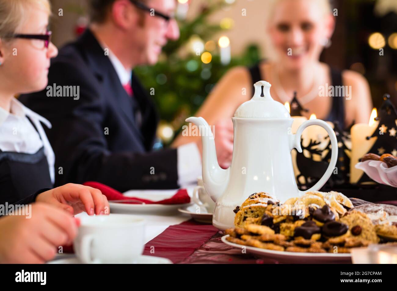 Les parents et les enfants célébrer Noël avec de boire du café et X-mas cookies Banque D'Images