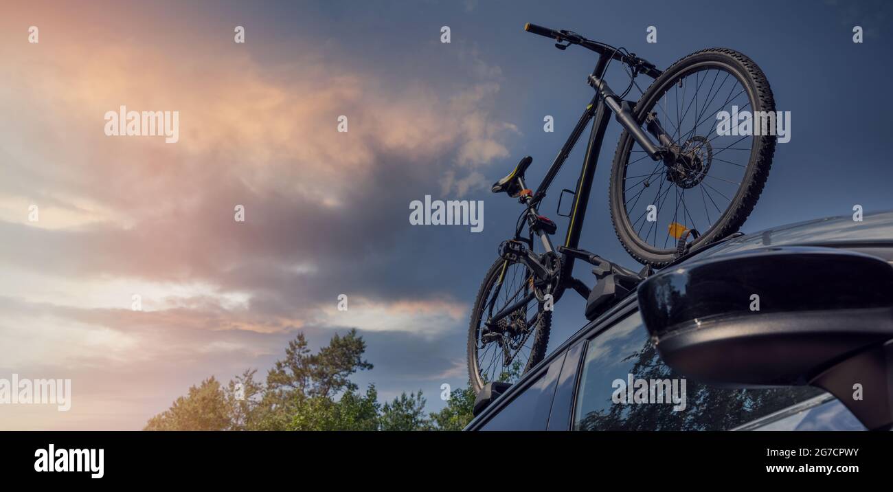 vélo sur le porte-bagages de toit contre le ciel de coucher de soleil. espace de copie Banque D'Images