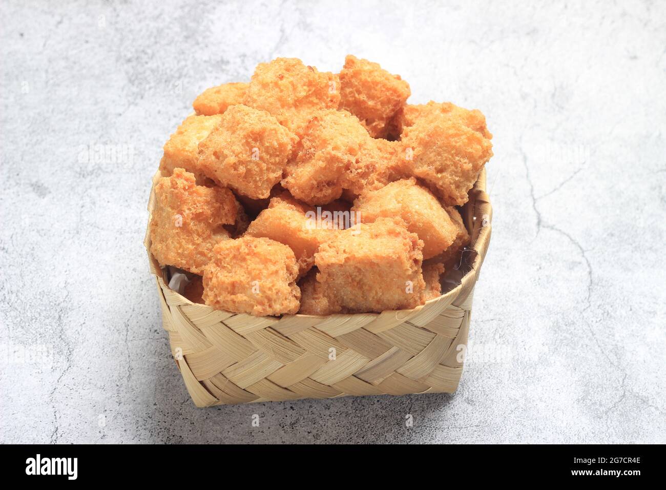 Vue de dessus photo, tahu krispi ou tofu croustillant au bol de bambou, besek sous le marbre abstrait brun Banque D'Images