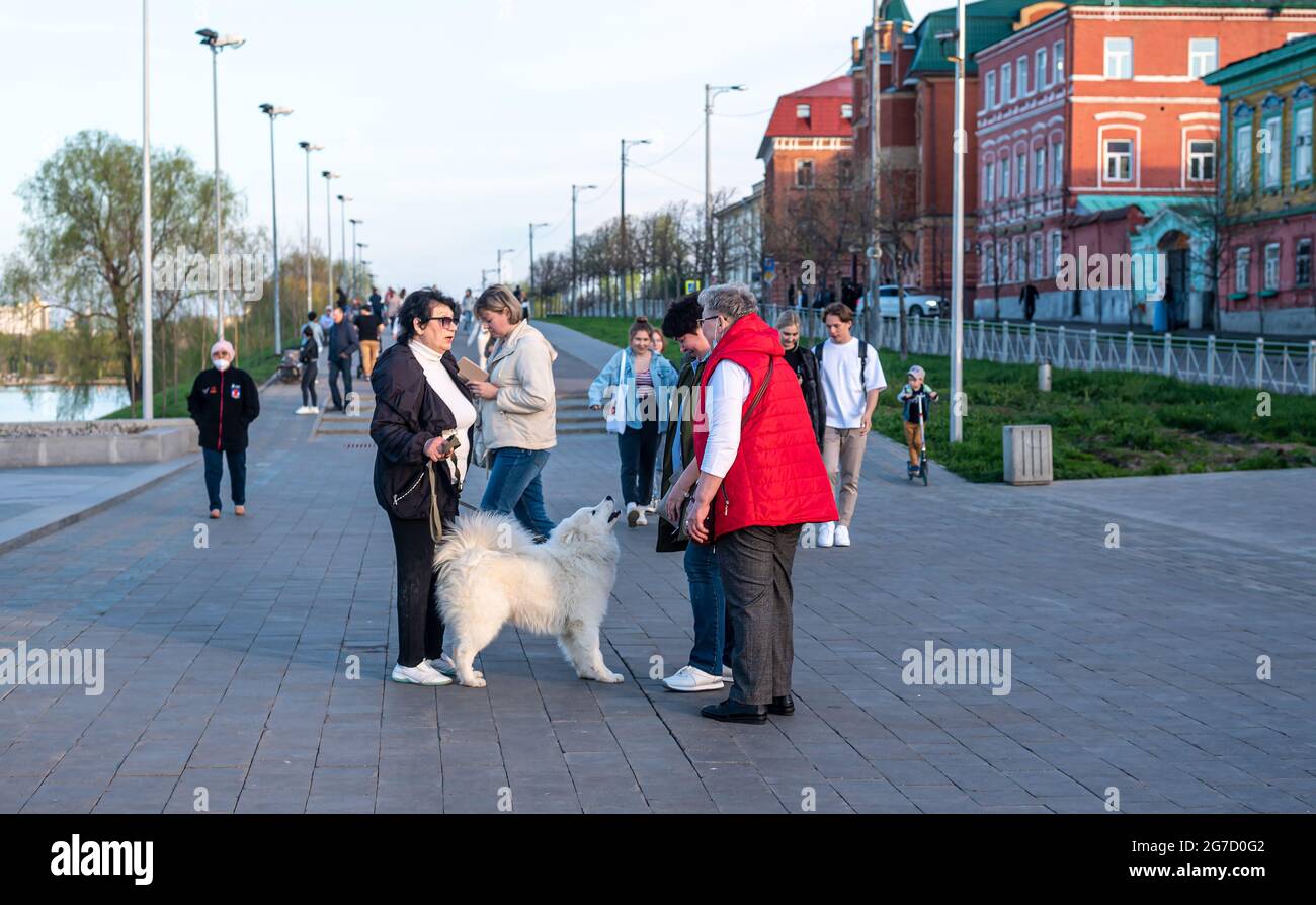 Des femmes âgées amies marchent avec le chien laika blanc sur le remblai Banque D'Images