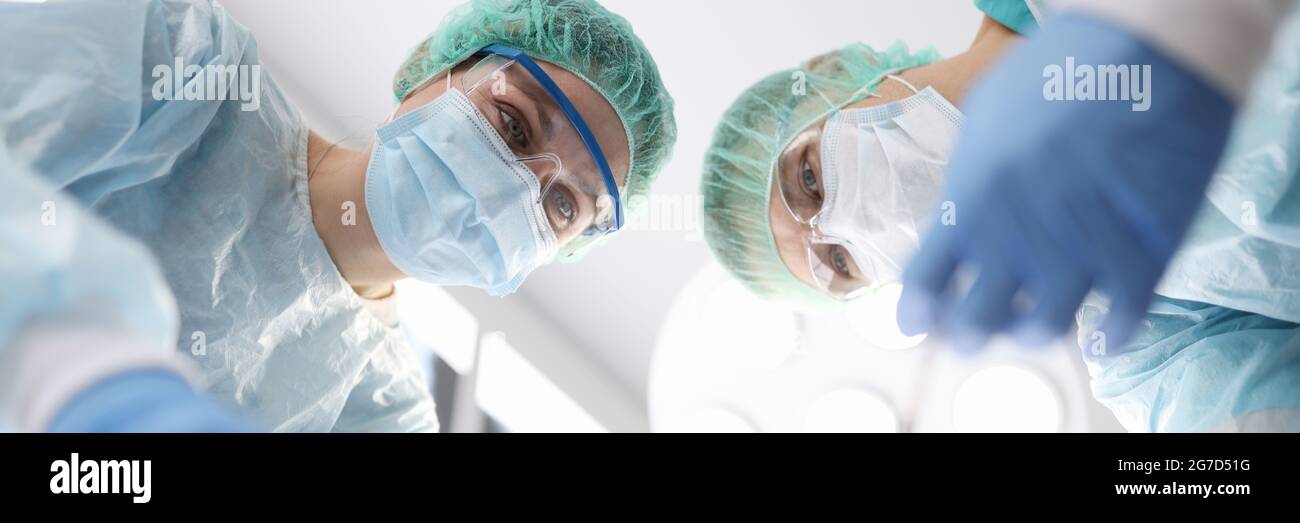 Groupe de médecins effectuant une opération chirurgicale en clinique Banque D'Images