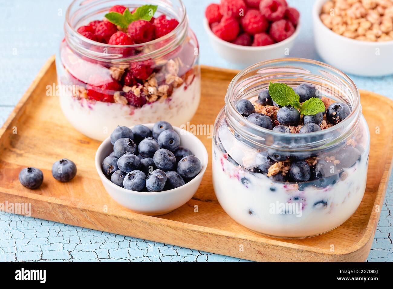 Petit déjeuner sain. Yaourt et fruits à la granola/muesli servis dans des bocaux en verre. Banque D'Images