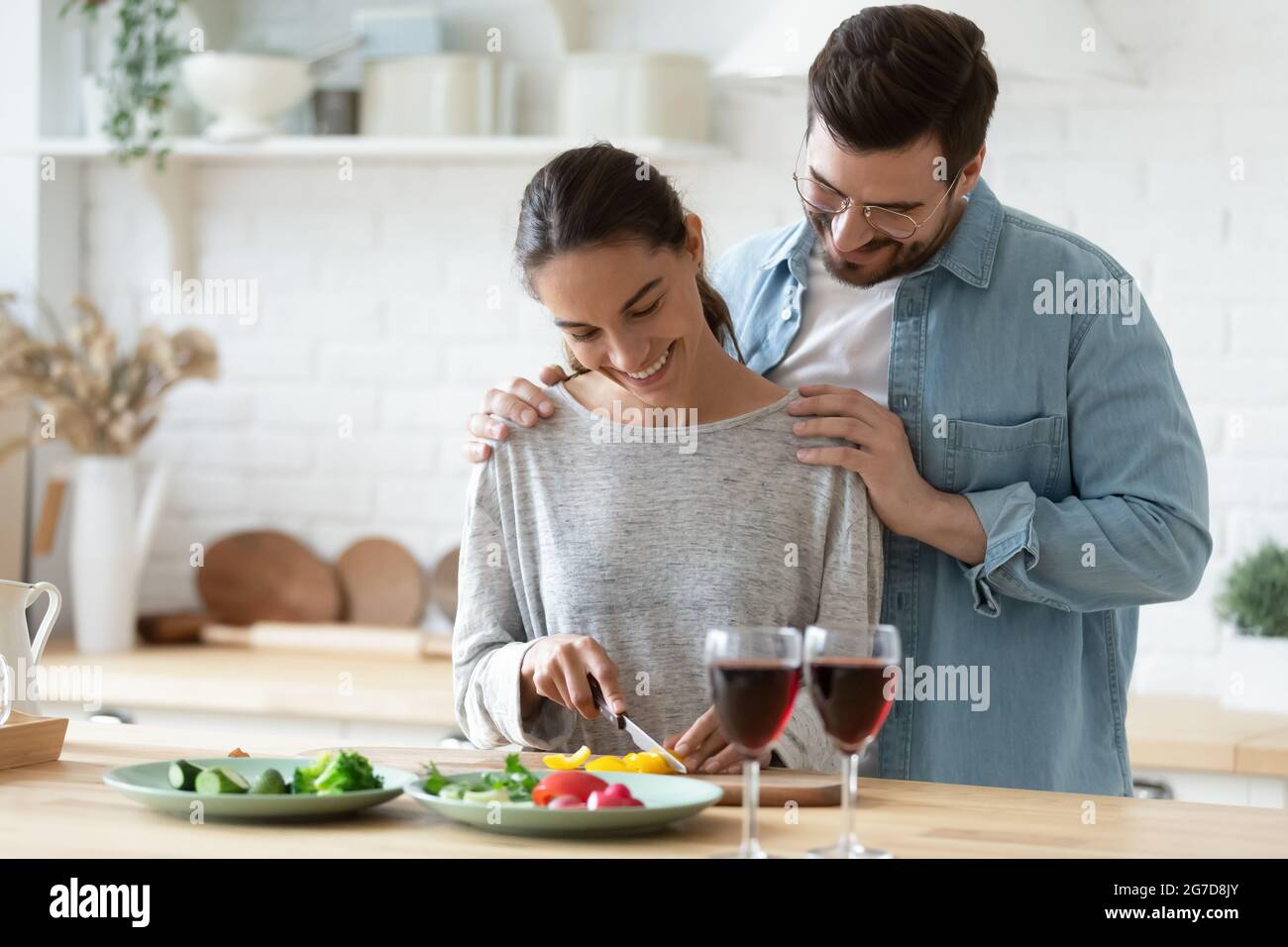 Une petite amie soignante prépare un dîner végétarien sain pour un petit ami Banque D'Images