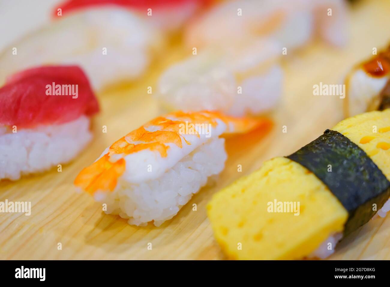 Gros plan sur les crevettes japonaises ebi et les sushis aux œufs grillés au tamagoyaki avec d'autres morceaux de riz pressé à la main, le nigirizushi, y compris le calmar ika, le hot Banque D'Images