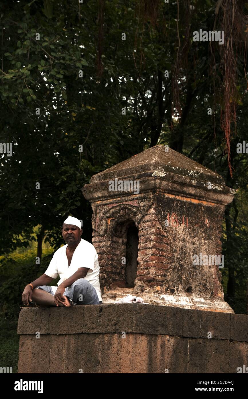 11 juillet 2021 à Mardhe Village, Satara, Inde. Old Man indien non identifié assis devant le petit Temple le matin, style de vie rural. Village indien Banque D'Images