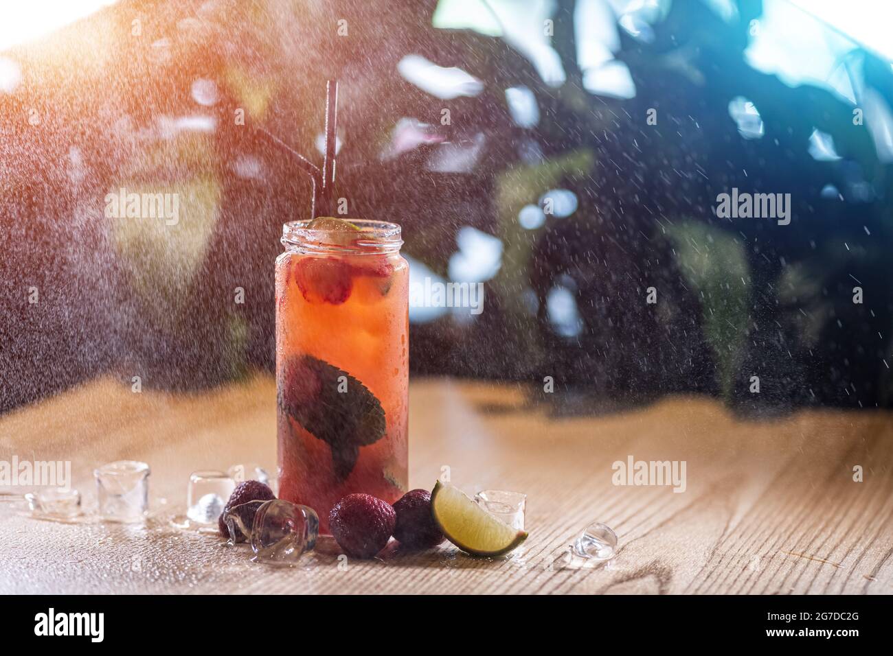 boisson à la citronnade aux fraises avec menthe et glace dans une bouteille de verre sous un jet d'eau Banque D'Images