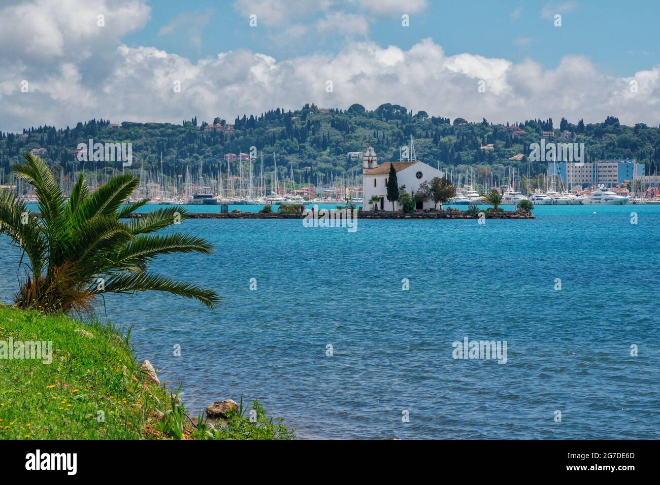 Île de Corfou, Grèce - 5 mai 2019 : vue sur la magnifique marina de Gouvia, l'ancienne église Ypapanti - petite maison blanche sur une jetée, village de villégiature et mountai Banque D'Images