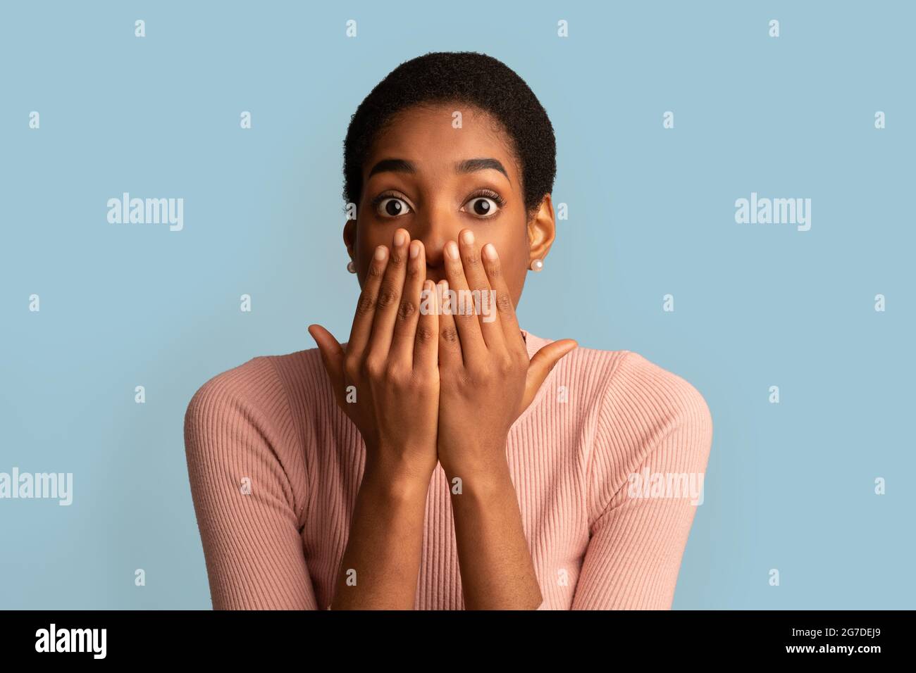 GUIDE D'UTILISATION Portrait d'une dame afro-américaine choquée couvrant la bouche avec les mains Banque D'Images