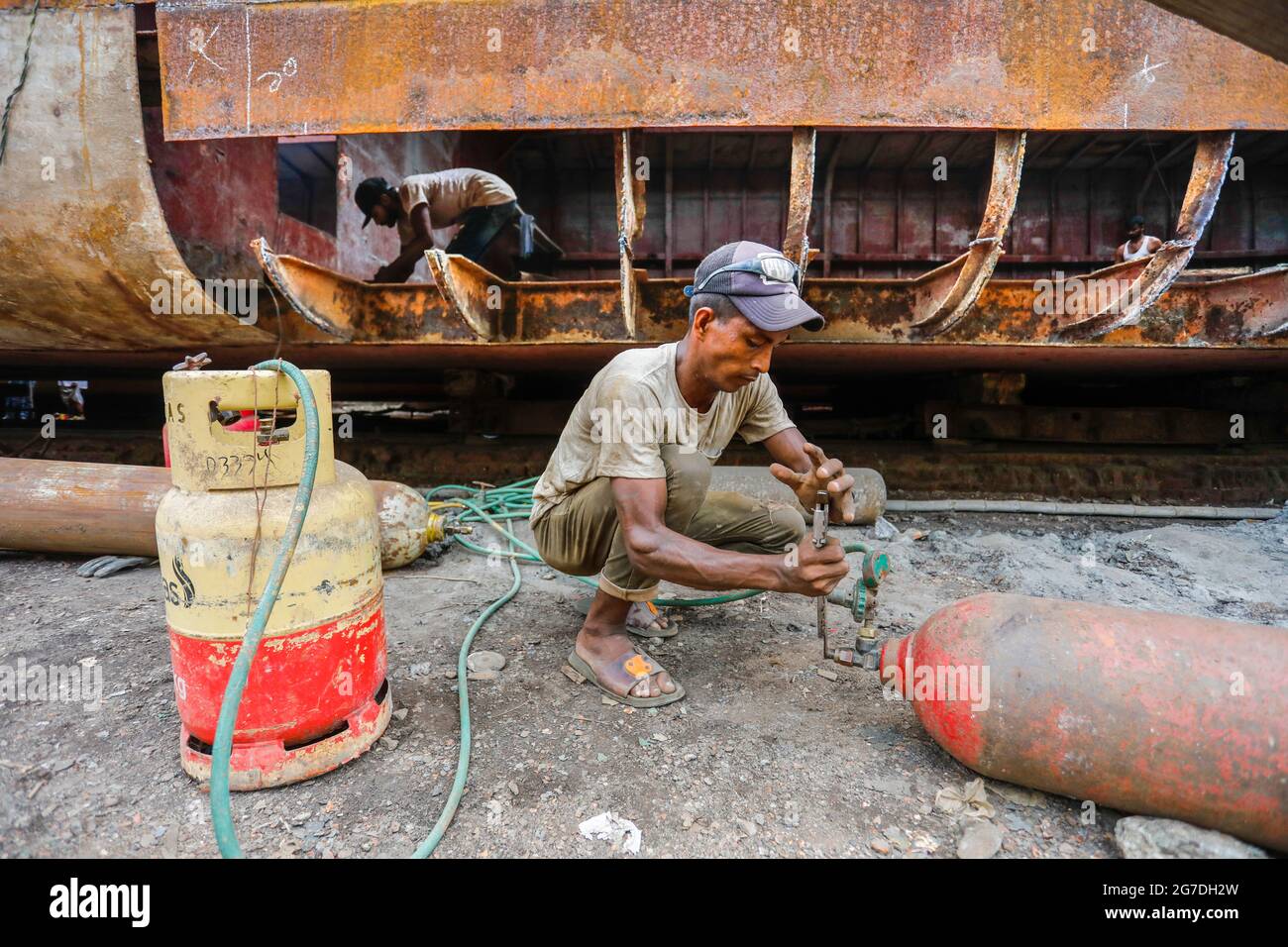 Les travailleurs bangladais réparent un navire dans un chantier naval situé sur la rive du Buriganga, à Keraniganj, près de Dhaka, Bangladesh, juillet 13, 2021. Avec un incrément Banque D'Images