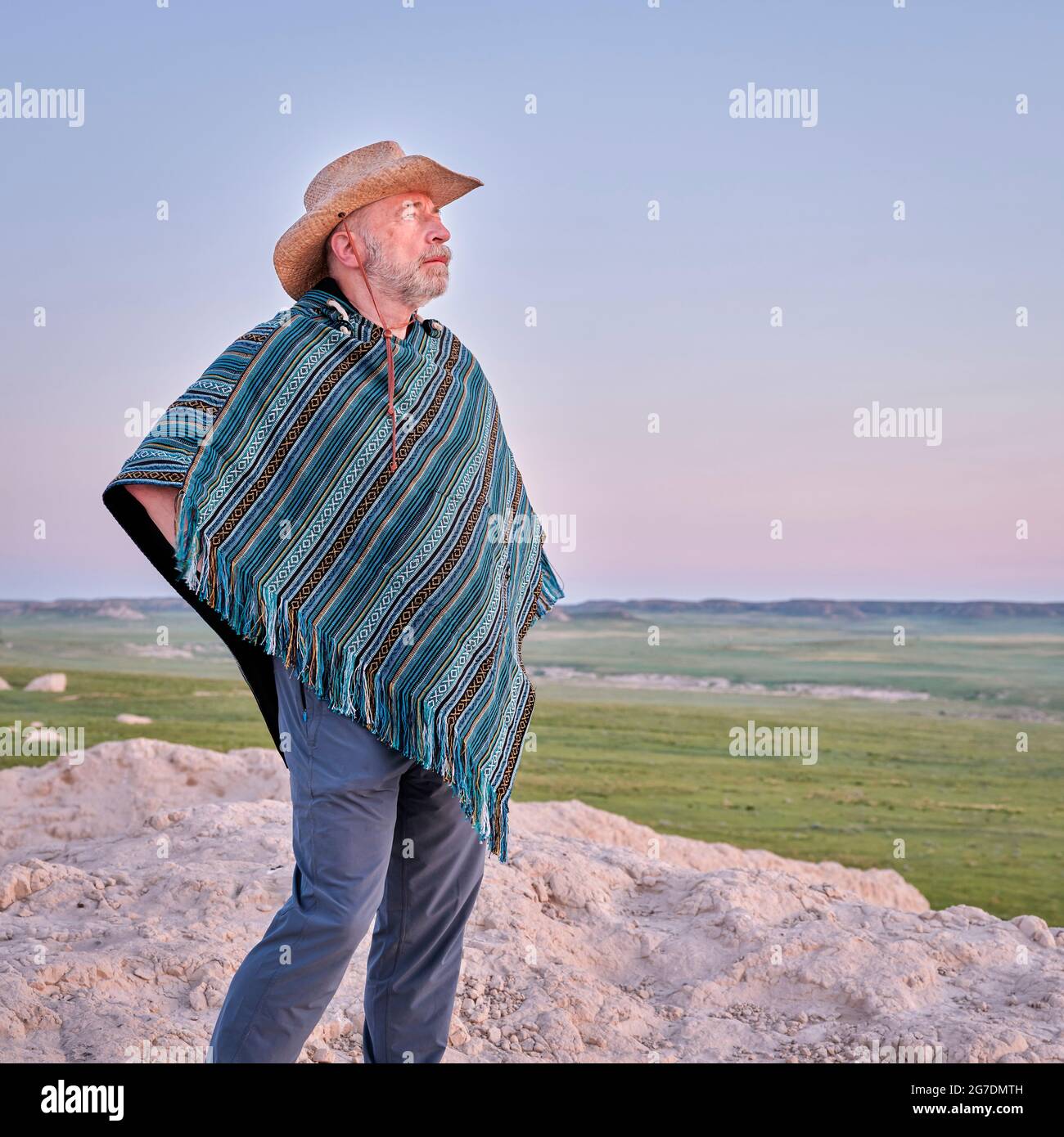 Un homme âgé dans un poncho mexicain et un chapeau de cowboy regarde le  lever du soleil d'été au-dessus de la prairie - Pawnee National Grassland  au Colorado Photo Stock - Alamy