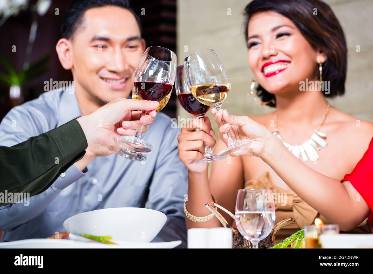 Les amis de l'Asie, deux couples, dîner dans un restaurant de fantaisie manger de la bonne nourriture et de boire du vin Banque D'Images