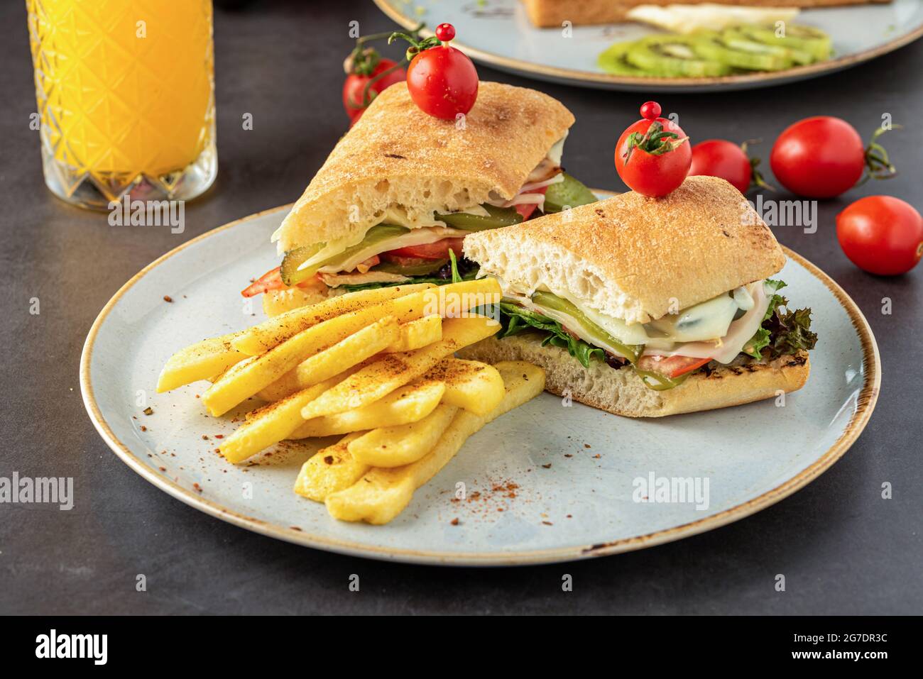 sandwich au jambon, au fromage et à la tomate avec frites et jus d'orange. Banque D'Images