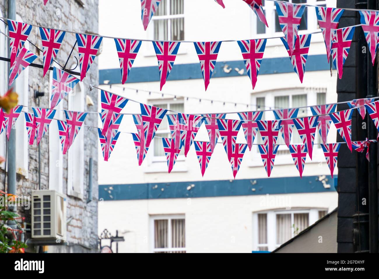 Drapeau de l'Union britannique suspendu triangulaire en préparation pour une fête de rue. Décorations festives de Union Jack Bunkting. Banque D'Images
