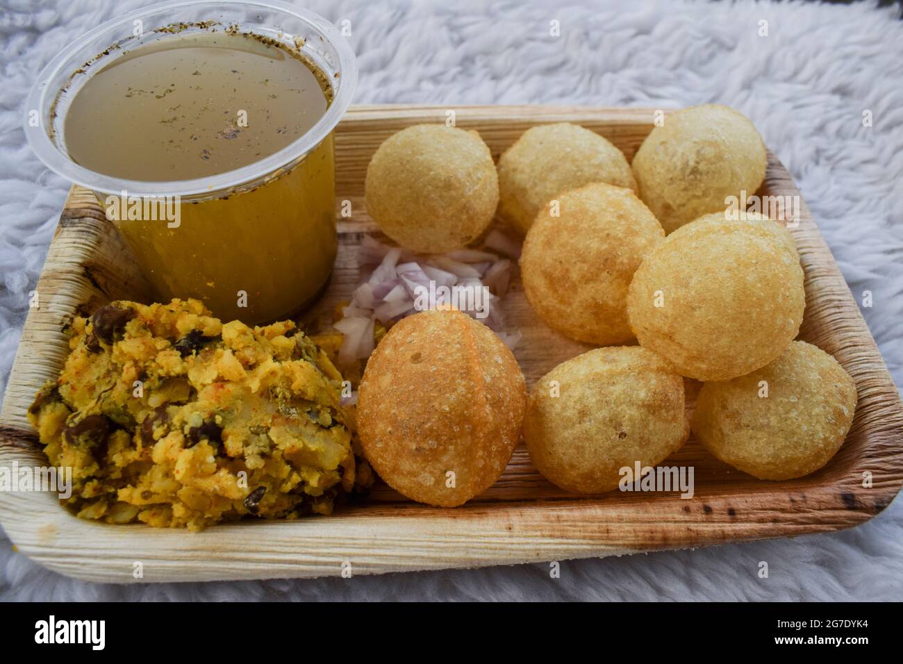 Délicieux en-cas indiens Pani puri avec de l'eau de chat masala et des oignons en tranches. Plat de collation indien traditionnel également connu sous le nom de boules d'eau, Golgappe, puchka. Banque D'Images