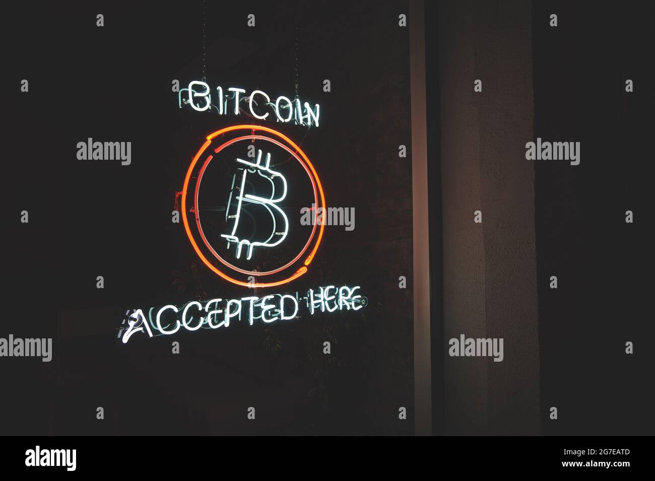 Bitcoin accepté ici crypto-monnaie LED néon signe dans une fenêtre de petite entreprise la nuit avec l'espace de copie Banque D'Images