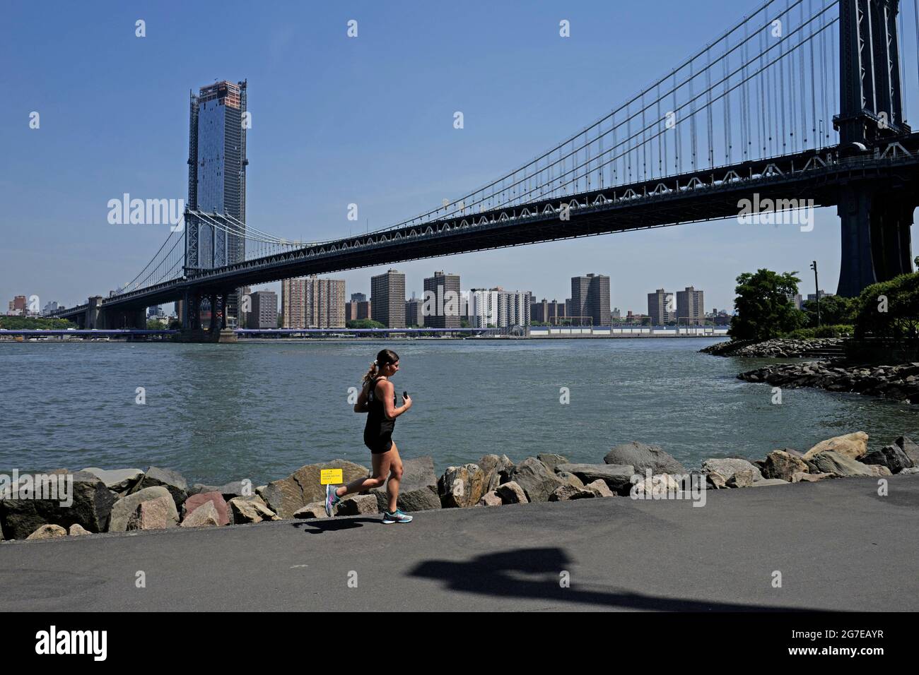 Femme coureur avec le pont de Manhattan en arrière-plan, à New York. Banque D'Images