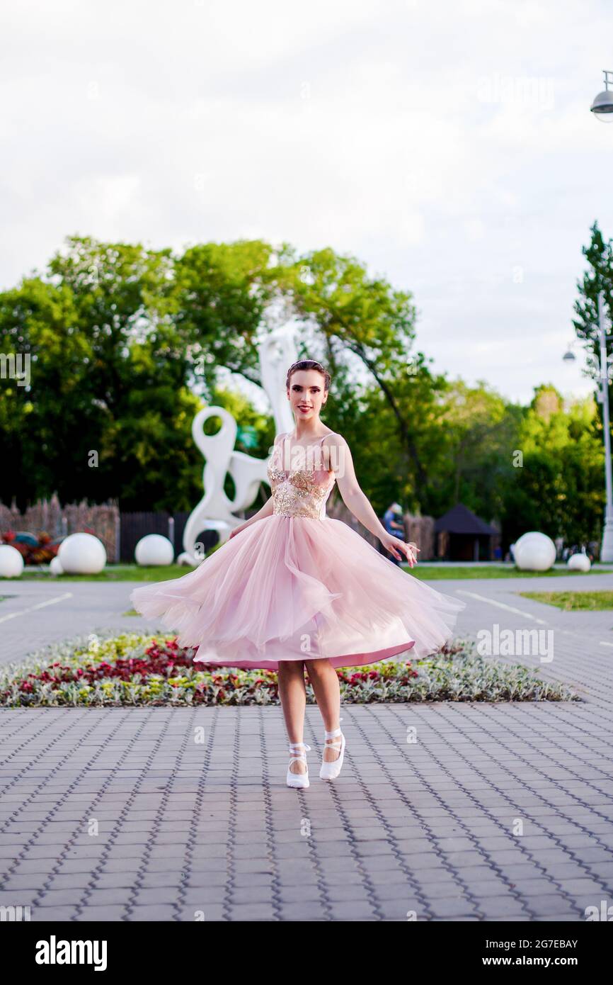 une jeune ballerine féminine élégante danse dans le parc, une jupe organza  luxuriante vole à l'écart du mouvement et de la danse Photo Stock - Alamy