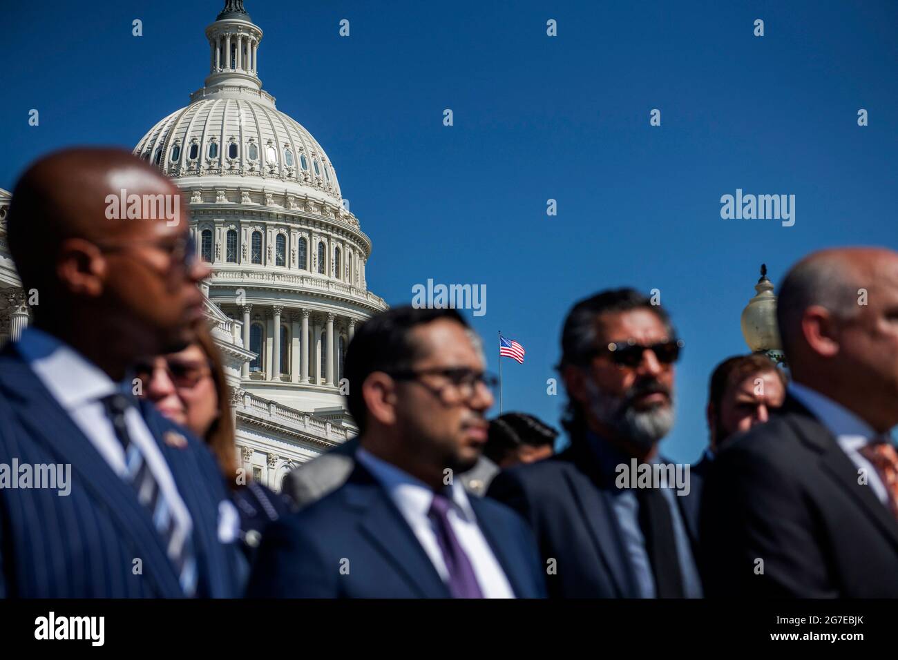 Alors que le drapeau américain survole le Capitole des États-Unis, un groupe de membres démocrates de la Chambre des représentants du Texas arrivent au Capitole pour une conférence de presse sur le droit de vote, à Washington, DC, le mardi 13 juillet, 2021. Dans un effort pour empêcher les Républicains d'adopter de nouvelles restrictions électorales, la Chambre des représentants de l'État du Texas est arrivée à l'aéroport international de Dulles hier soir après avoir fui leur État dans une paire de jets charters. Crédit : Rod Lamkey/CNP Banque D'Images