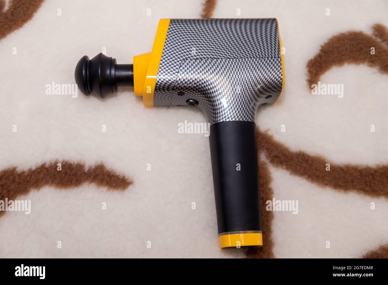 Pistolet de massage thérapeutique professionnel sans fil portable sur couverture maison. Masseur à percussion de tissus musculaires profonds pour les athlètes, détend, reliev Banque D'Images